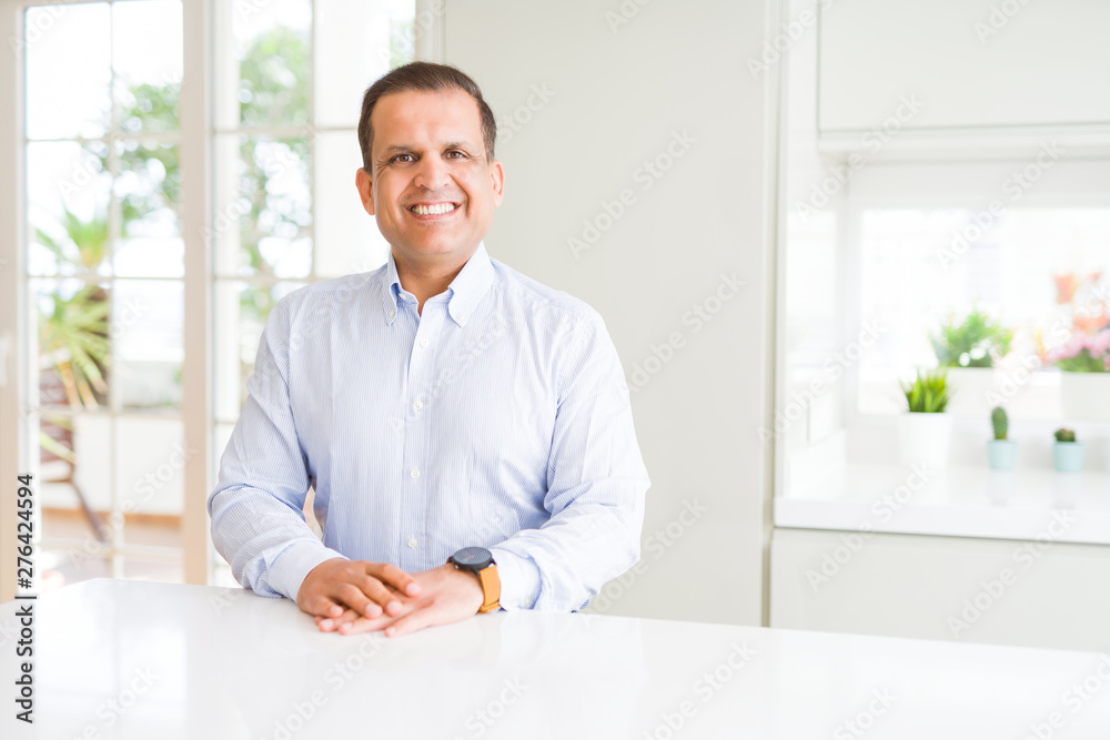 Middle age man sitting at home with a happy and cool smile on face. Lucky person. Middle age man sitting at home with a happy and cool smile on face. Lucky person.