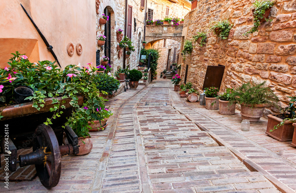 Romantic floral street in Spello, medieval town in Umbria, Italy. Famous for narrow lanes and balconies and windows with flowers