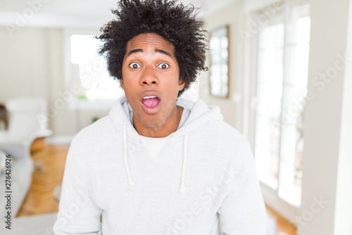 African American man wearing sweatshirt afraid and shocked with surprise expression, fear and excited face.