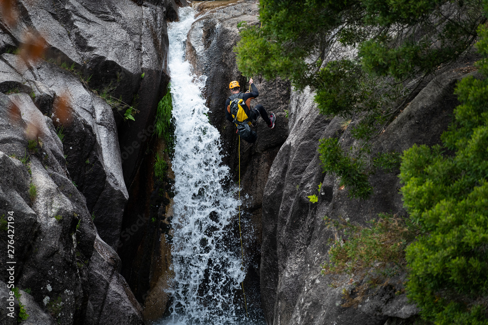 Cascata do Arado, Vilar da Veiga, Portugal - June 10, 2019: One man rappelling the Arado Waterfall (cascata do arado) in the Peneda Geres National Park, in Portugal.