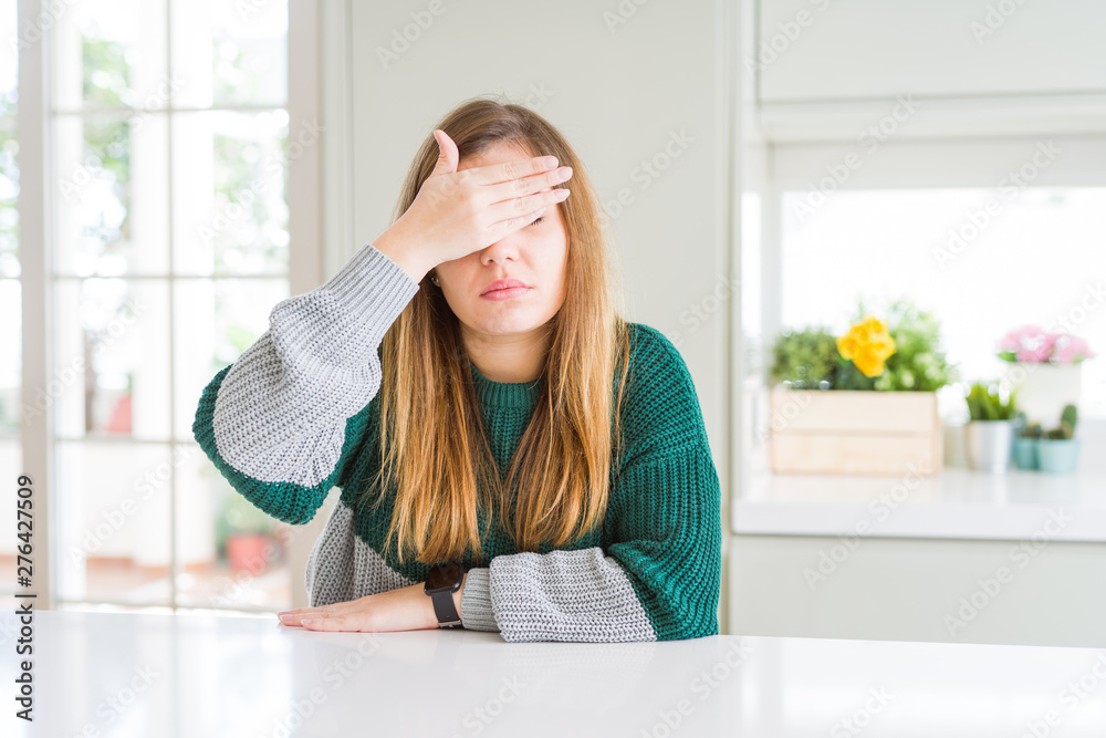 Young beautiful plus size woman wearing casual striped sweater covering eyes with hand, looking serious and sad. Sightless, hiding and rejection concept