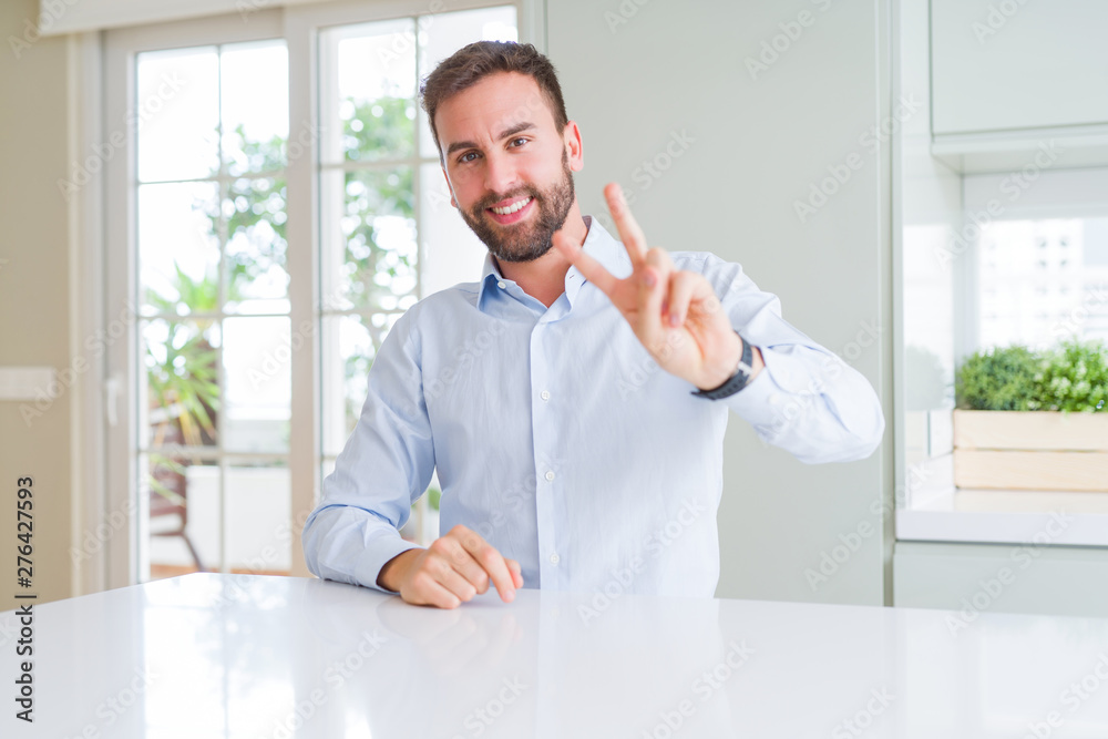 Handsome business man smiling looking to the camera showing fingers doing victory sign. Number two. Handsome business man smiling looking to the camera showing fingers doing victory sign. Number two.