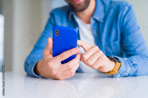 Close up of man hands using smartphone and smiling