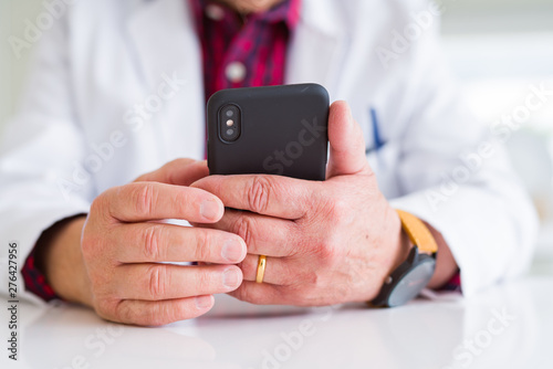 Close up of doctor hands using smartphone at the clinic