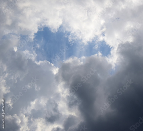 Der blaue Himmel bricht durch die dunkle Regenwolkendecke