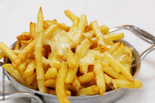 Tableau sur toile cheesy french fries in a metal bowl with white background