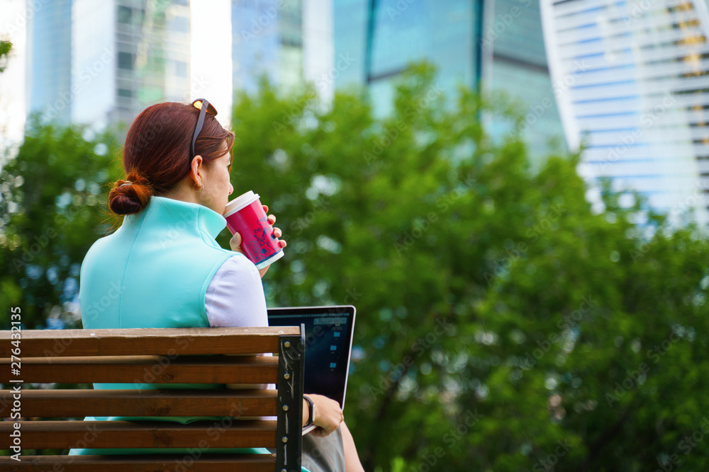 Fototapeta premium Portrait of business woman sitting with laptop and cup of coffee