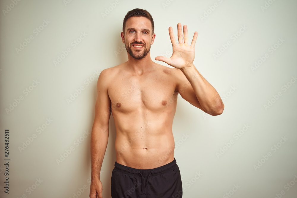 Fototapeta premium Young handsome shirtless man over isolated background showing and pointing up with fingers number five while smiling confident and happy.