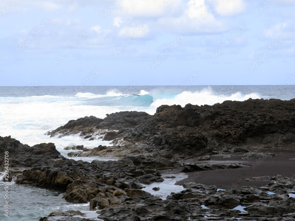 scrambled sea waves crashing against lava rocks