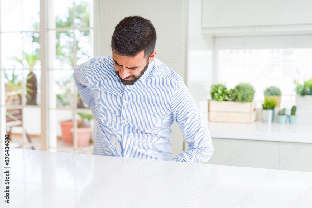Handsome hispanic business man Suffering of backache, touching back with hand, muscular pain