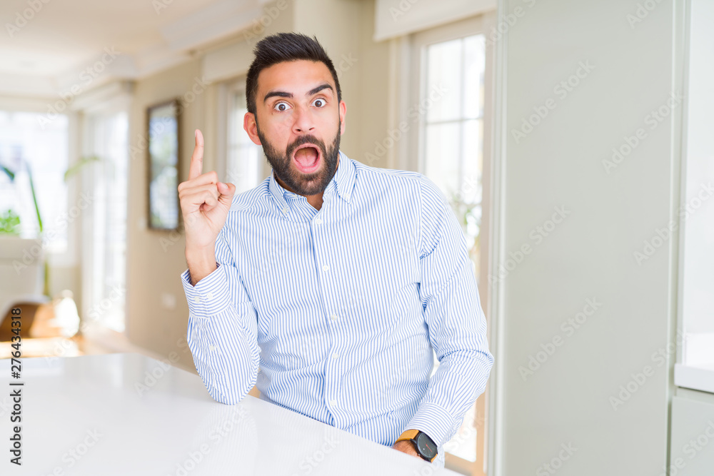 Handsome hispanic business man pointing finger up with successful idea. Exited and happy. Number one. Handsome hispanic business man pointing finger up with successful idea. Exited and happy. Number one.