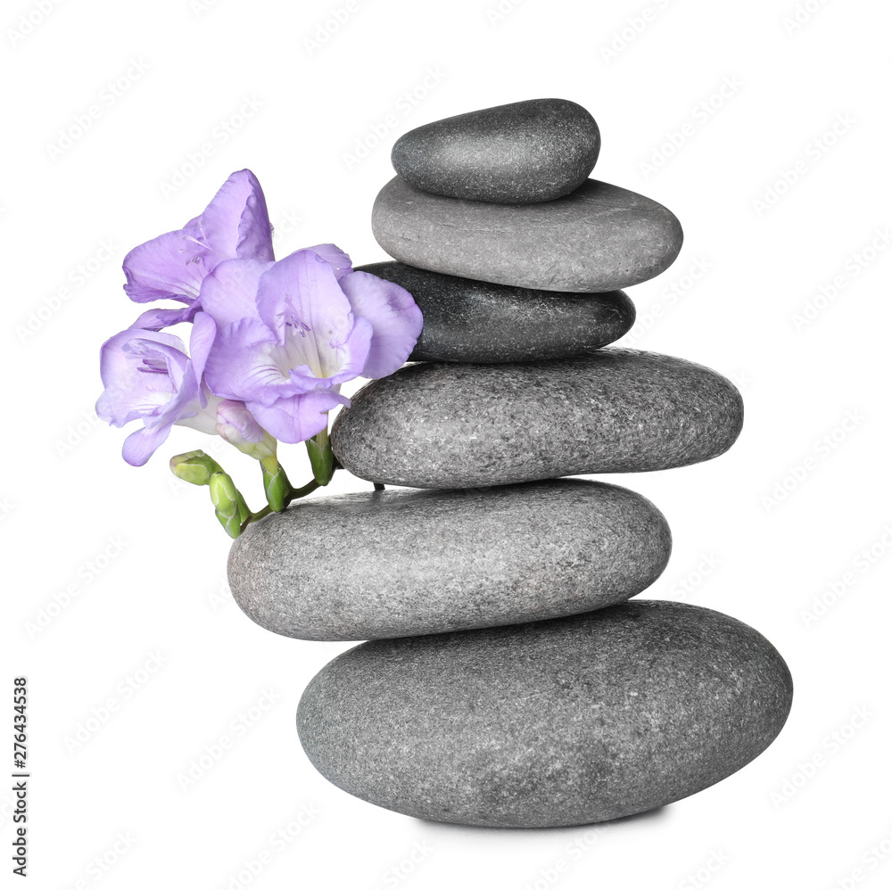 Stack of grey spa stones and fresh flowers isolated on white Stack of grey spa stones and fresh flowers isolated on white