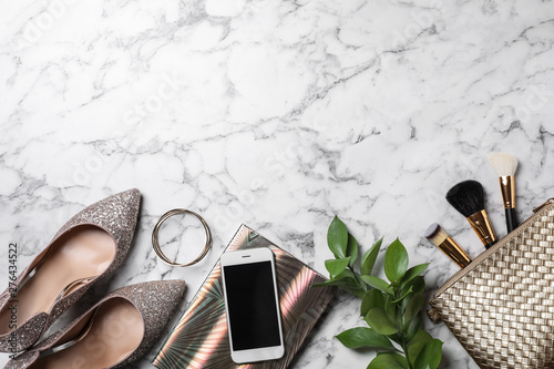 Flat lay composition with mobile phone and blogger's stuff on marble background, space for text