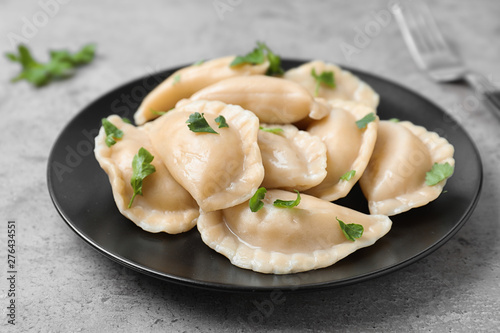 Plate of tasty cooked dumplings on stone surface