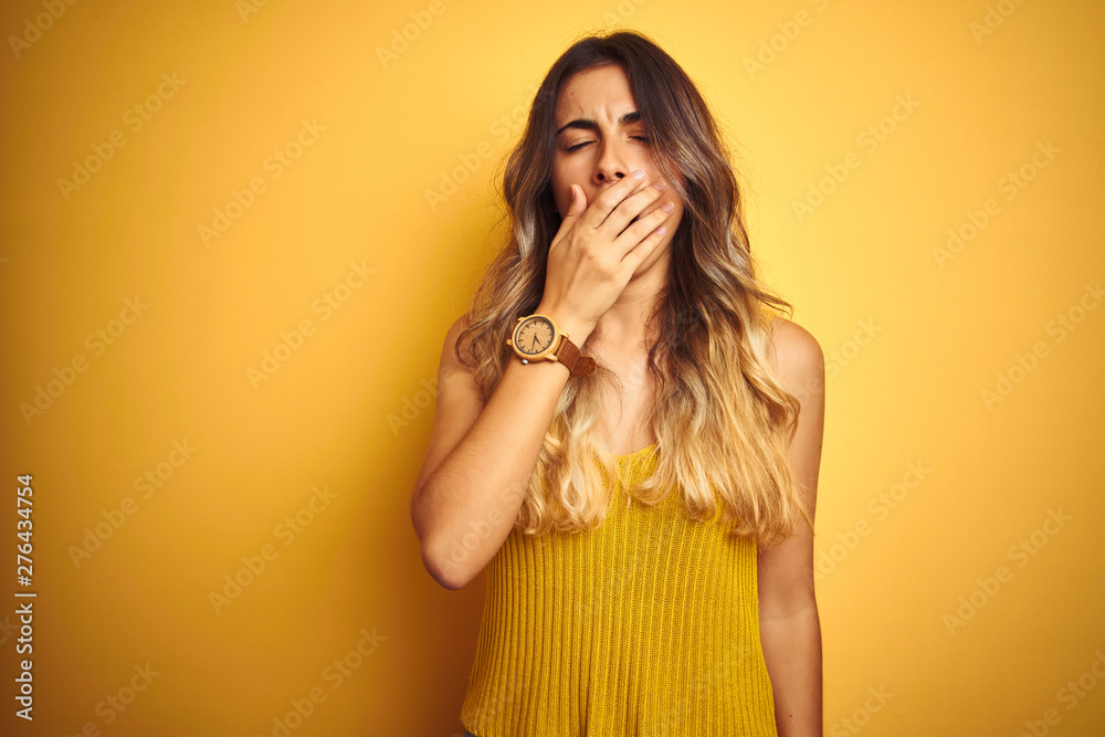 Young beautiful woman wearing t-shirt over yellow isolated background bored yawning tired covering mouth with hand. Restless and sleepiness. Young beautiful woman wearing t-shirt over yellow isolated background bored yawning tired covering mouth with hand. Restless and sleepiness.