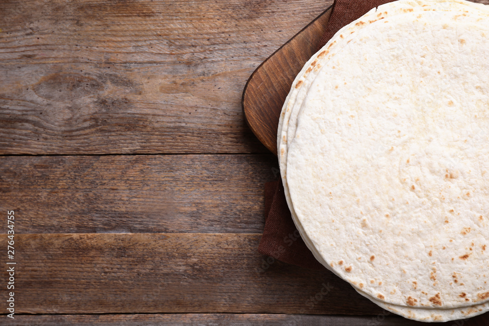 Board with tortillas on wooden table, top view. Space for text Board with tortillas on wooden table, top view. Space for text
