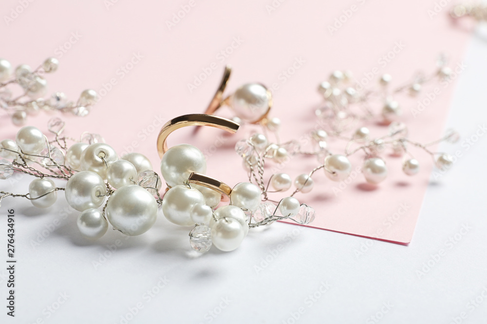 Elegant jewelry with pearls on color background, closeup Elegant jewelry with pearls on color background, closeup