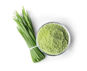 Fresh wheat grass and bowl with powder on white background, top view