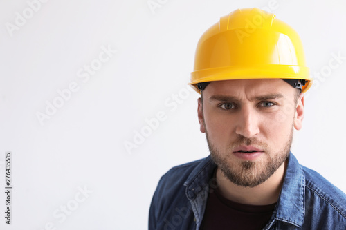 Young working man in hardhat on white background