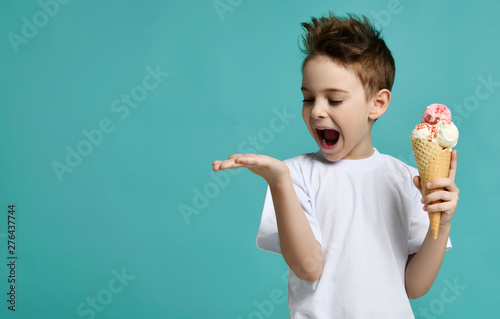 Foto Baby boy kid hold three scoops of strawberry and vanilla ice-cream in waffles co