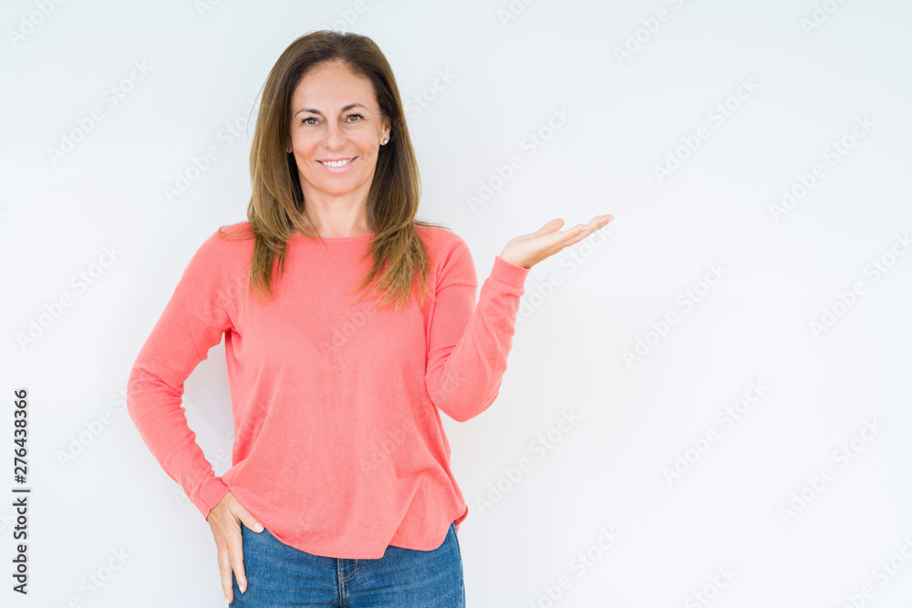 Beautiful middle age woman over isolated background smiling cheerful presenting and pointing with palm of hand looking at the camera.