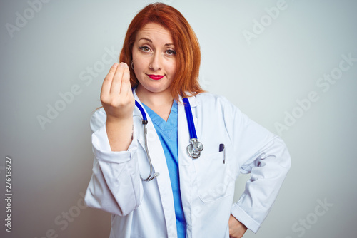 Young redhead doctor woman using stethoscope over white isolated background Doing Italian gesture with hand and fingers confident expression