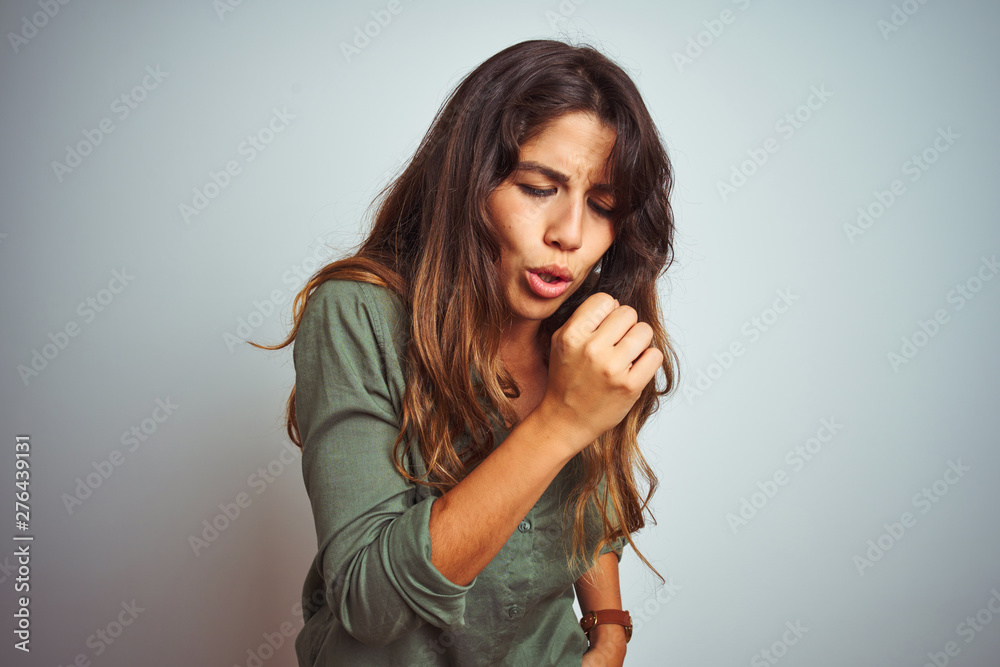 Fototapeta premium Young beautiful woman wearing green shirt standing over grey isolated background feeling unwell and coughing as symptom for cold or bronchitis. Healthcare concept.