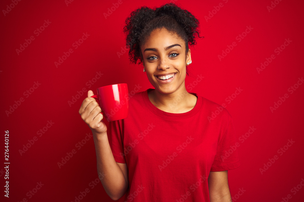 Young african american woman drinking a cup of coffee over isolated red background with a happy face standing and smiling with a confident smile showing teeth Young african american woman drinking a cup of coffee over isolated red background with a happy face standing and smiling with a confident smile showing teeth