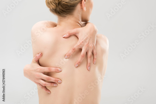 back view of sexy naked woman embracing herself isolated on grey