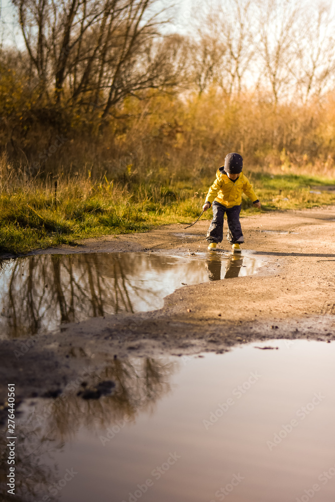 Little boy playing in the puddles after rain Little boy playing in the puddles after rain