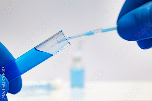 Scientist hand holding laboratory test tube and conducts scientific research on light background