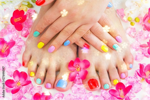 Closeup photo of a beautiful female feet with pedicure and hands with manicure
