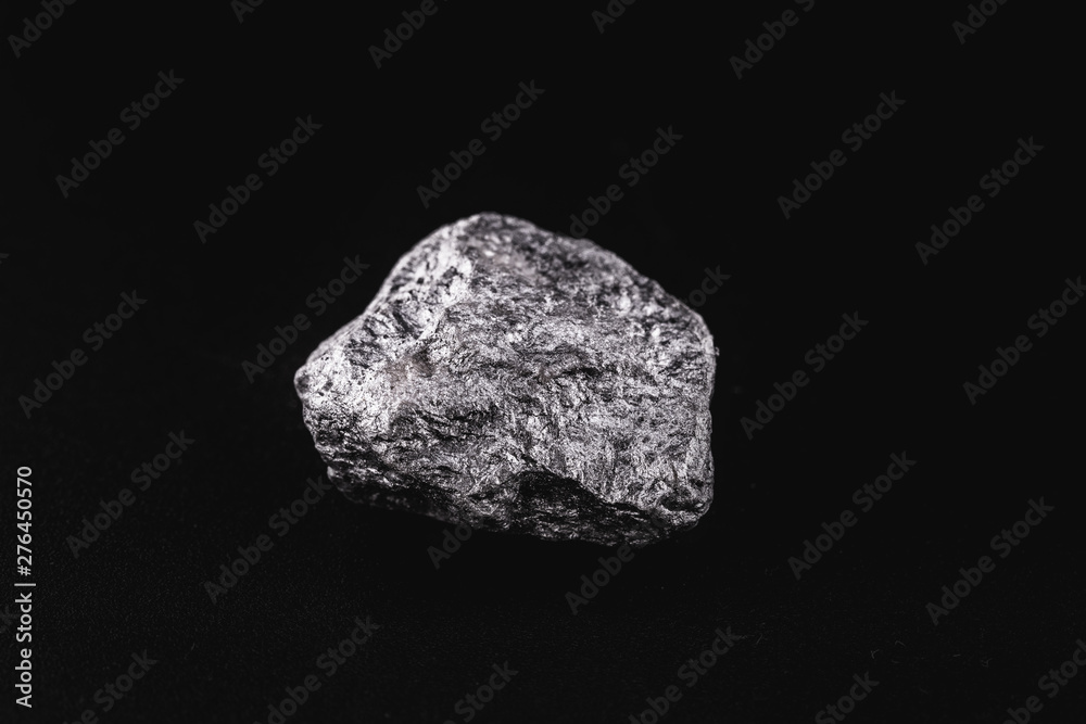Manganese in the raw state. Manganese stone isolated on black background. Mineral extraction of heavy metal. Manganese in the raw state. Manganese stone isolated on black background. Mineral extraction of heavy metal.
