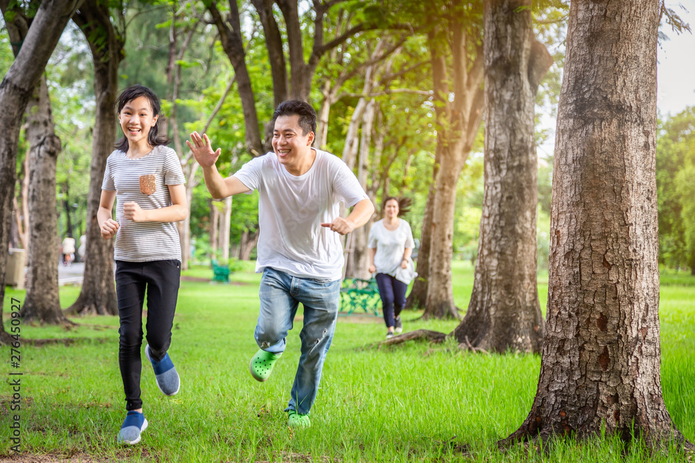 Happy family,asian little child girl or daughter playing tag game,running joyful with father,mother in summer green nature,dad,mom having fun,play touch and laughing in outdoor park,parents enjoy game
