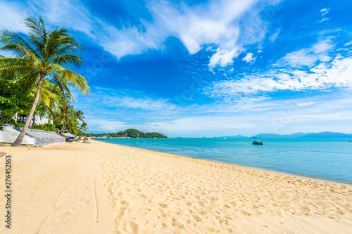 Fototapeta Naklejka Na Ścianę i Meble -  Beautiful tropical beach sea and ocean with coconut palm tree  and umbrella and chair on blue sky and white cloud