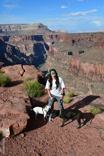 Young woman with her two dogs at Toroweap Overlook in Grand Canyon National Park, Arizona.