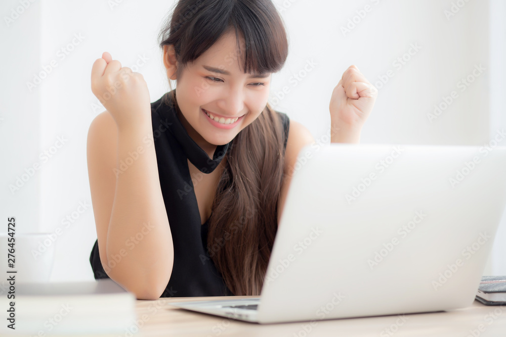 Beautiful portrait asian young woman smile working online laptop computer with happy satisfied sitting on desk office, girl using notebook with excited and glad, business and success concept. Beautiful portrait asian young woman smile working online laptop computer with happy satisfied sitting on desk office, girl using notebook with excited and glad, business and success concept.