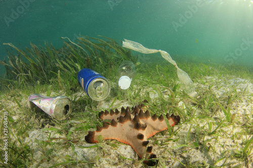 Tin cans, plastic bottles and bags pollution of coral reef in ocean 