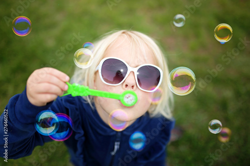 Little Girl Child Blowing Bubbles Outside on a Summer Day
