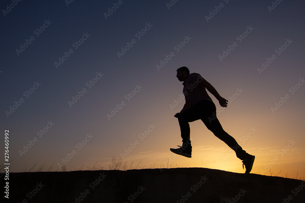 silhouette of man running at sunrise