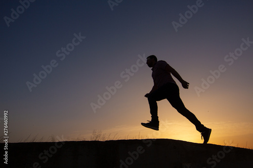 silhouette of man running at sunrise © robcartorres