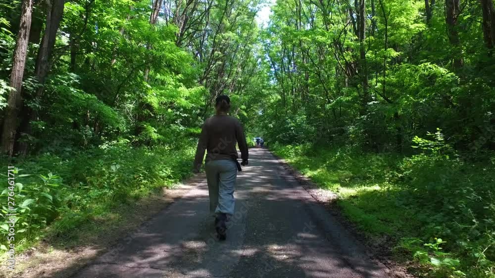 Woman tourist walking along tree lined path, Chernobyl visitor tour Woman tourist walking along tree lined path, Chernobyl visitor tour