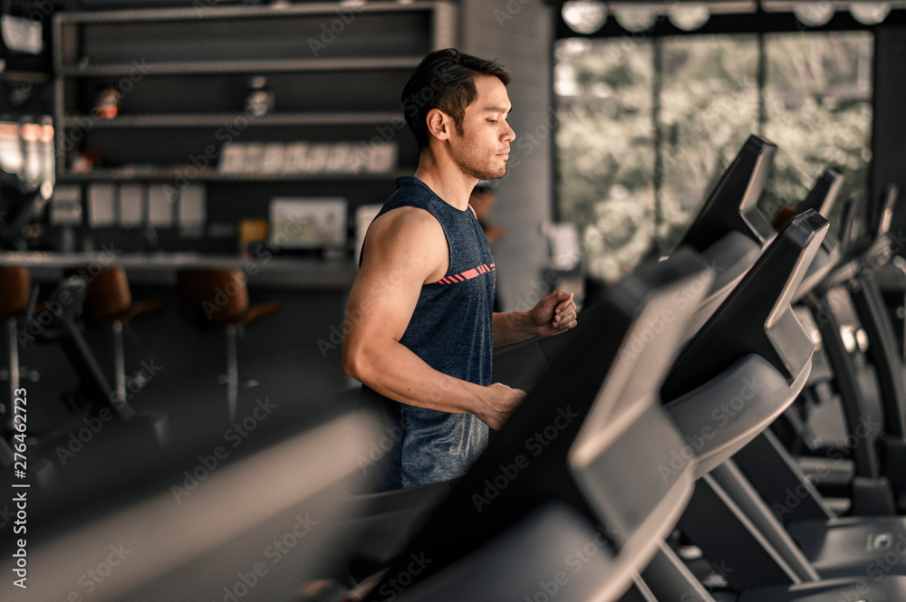 man in sportswear running on treadmill at gym man in sportswear running on treadmill at gym