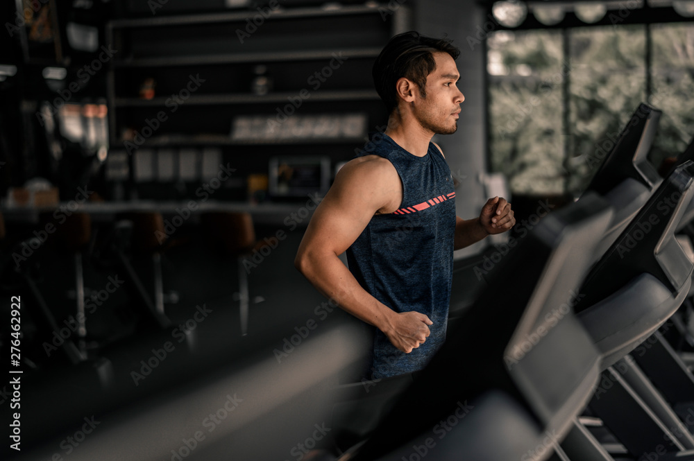 man in sportswear running on treadmill at gym man in sportswear running on treadmill at gym