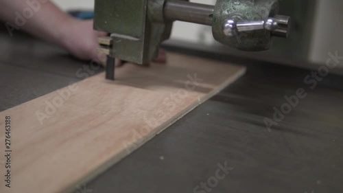 Man cutting wood with bandsaw 100fps slowed to 30% photo