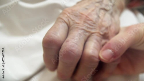 young person with tears confronting elderly dying person. last goodbye, at the hospital bed. Point of view shot , partially blurred to show tears photo