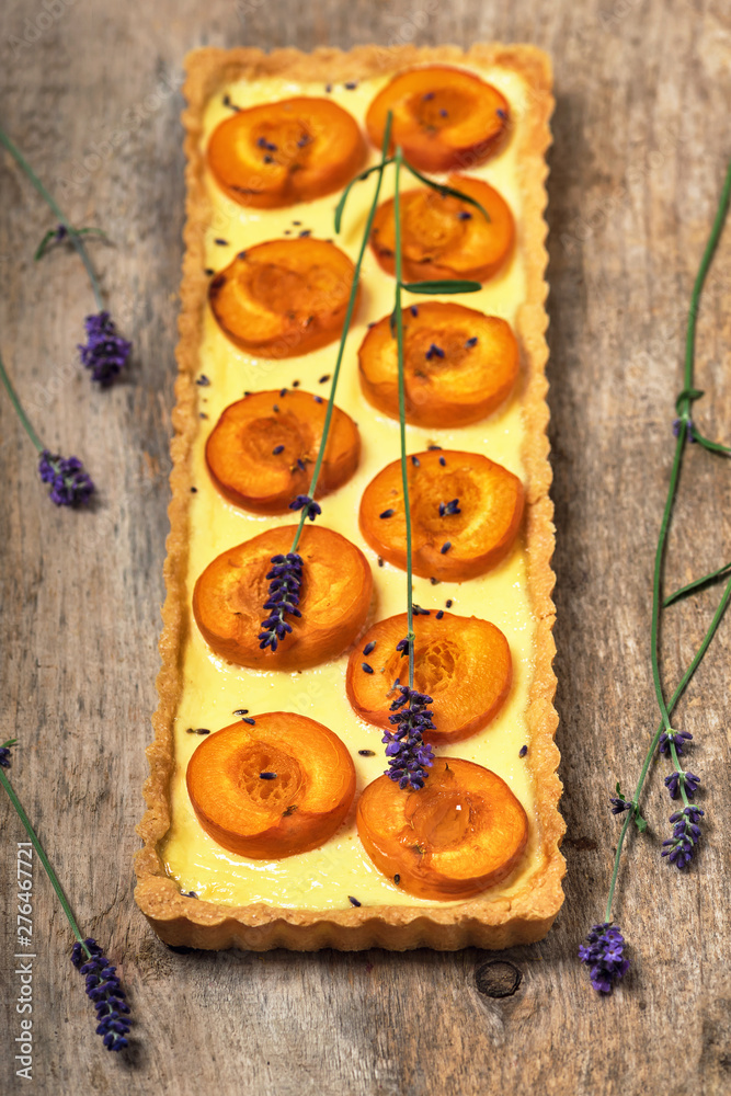 Tradition homemade french tart with apricots and lavender flowers on rustic wooden background. Selective focus. Tradition homemade french tart with apricots and lavender flowers on rustic wooden background. Selective focus.