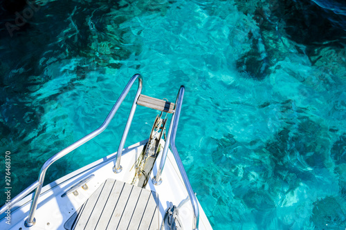 (Selective focus) Stunning view of a bow of a yacht sailing on a beautiful turquoise and transparent sea. Costa Smeralda (Emerald Coast) Sardinia, Italy. 