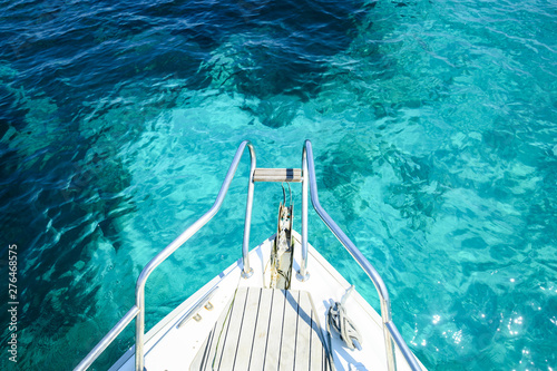 (Selective focus) Stunning view of a bow of a yacht sailing on a beautiful turquoise and transparent sea. Costa Smeralda (Emerald Coast) Sardinia, Italy.  © Travel Wild