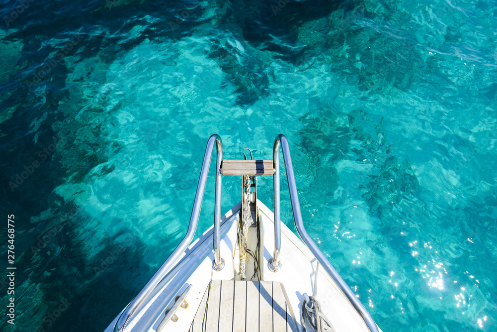 (Selective focus) Stunning view of a bow of a yacht sailing on a beautiful turquoise and transparent sea. (Emerald Coast) Sardinia, Italy.